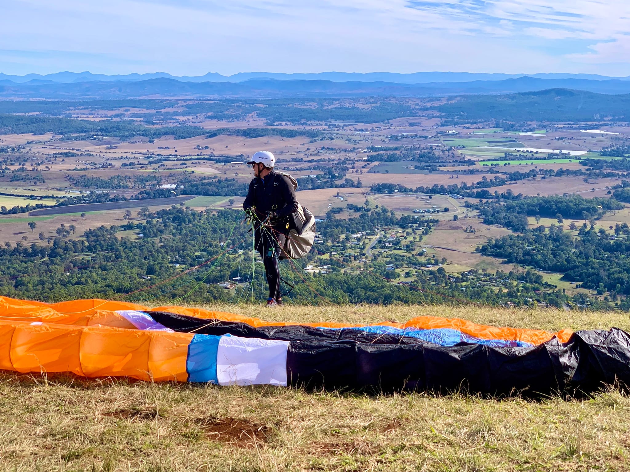 A paraglider at the launch on Tamborine Mountain, with farmland stretching out below