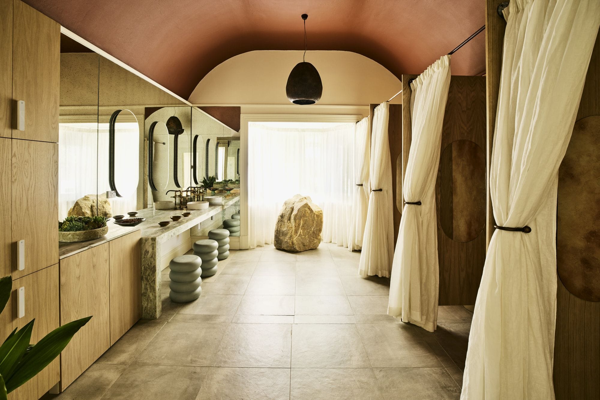 The change room at POND Bathhouse, with timber lockers and a terracotta arched ceiling