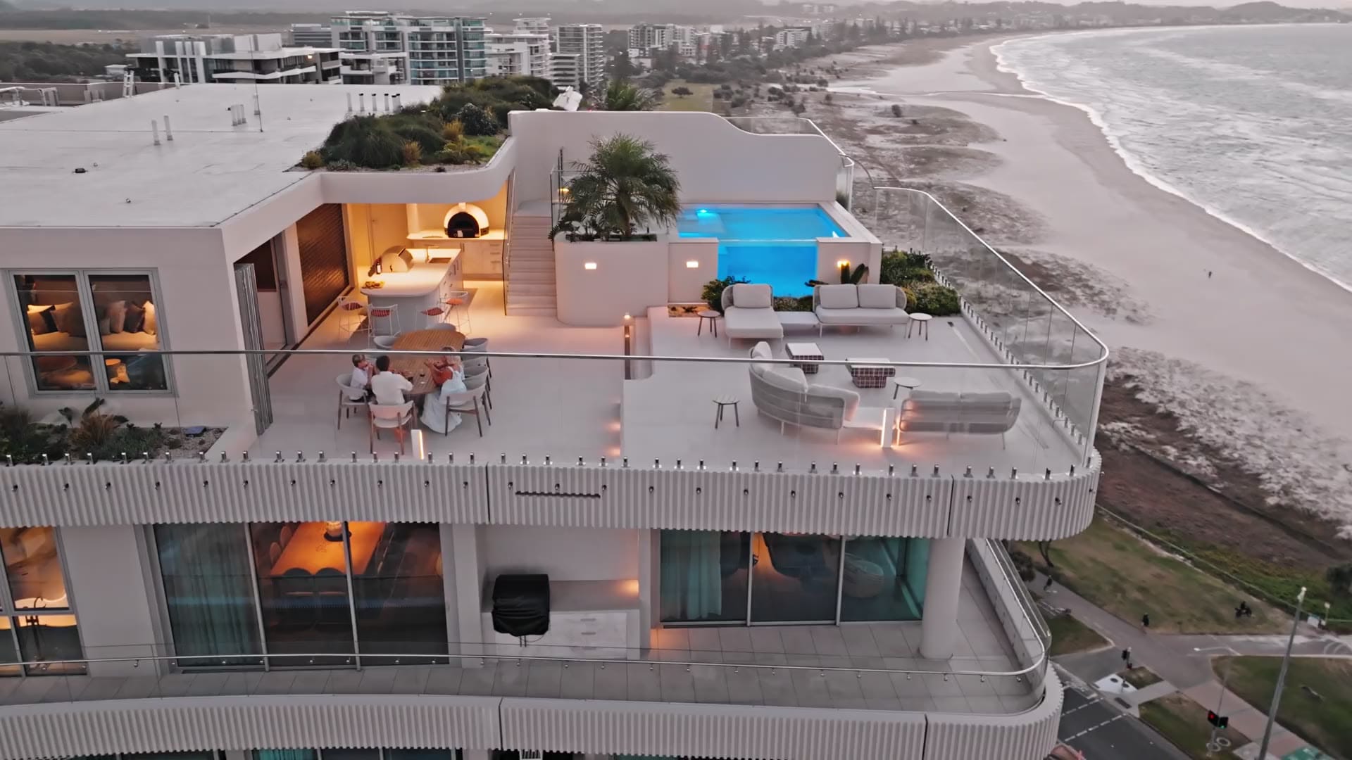 Aerial view at dusk of the RISE penthouse in Coolangatta, with its rooftop pool above the beach