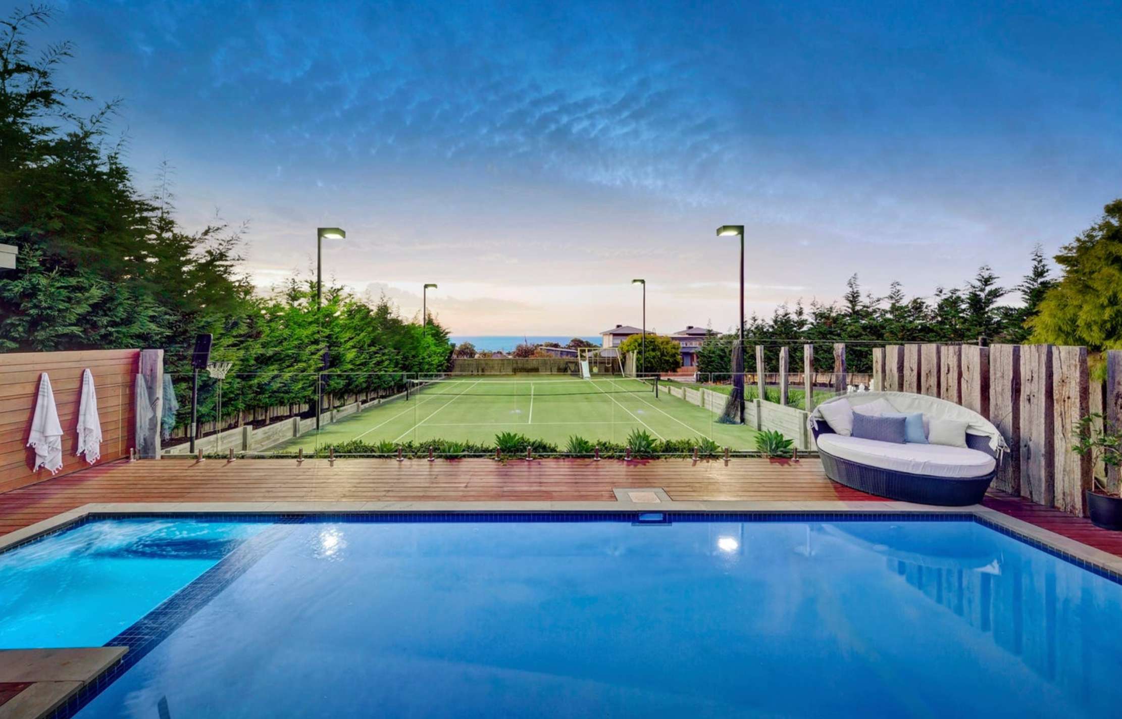 Pool and tennis court at dusk at The Hull, Mount Martha
