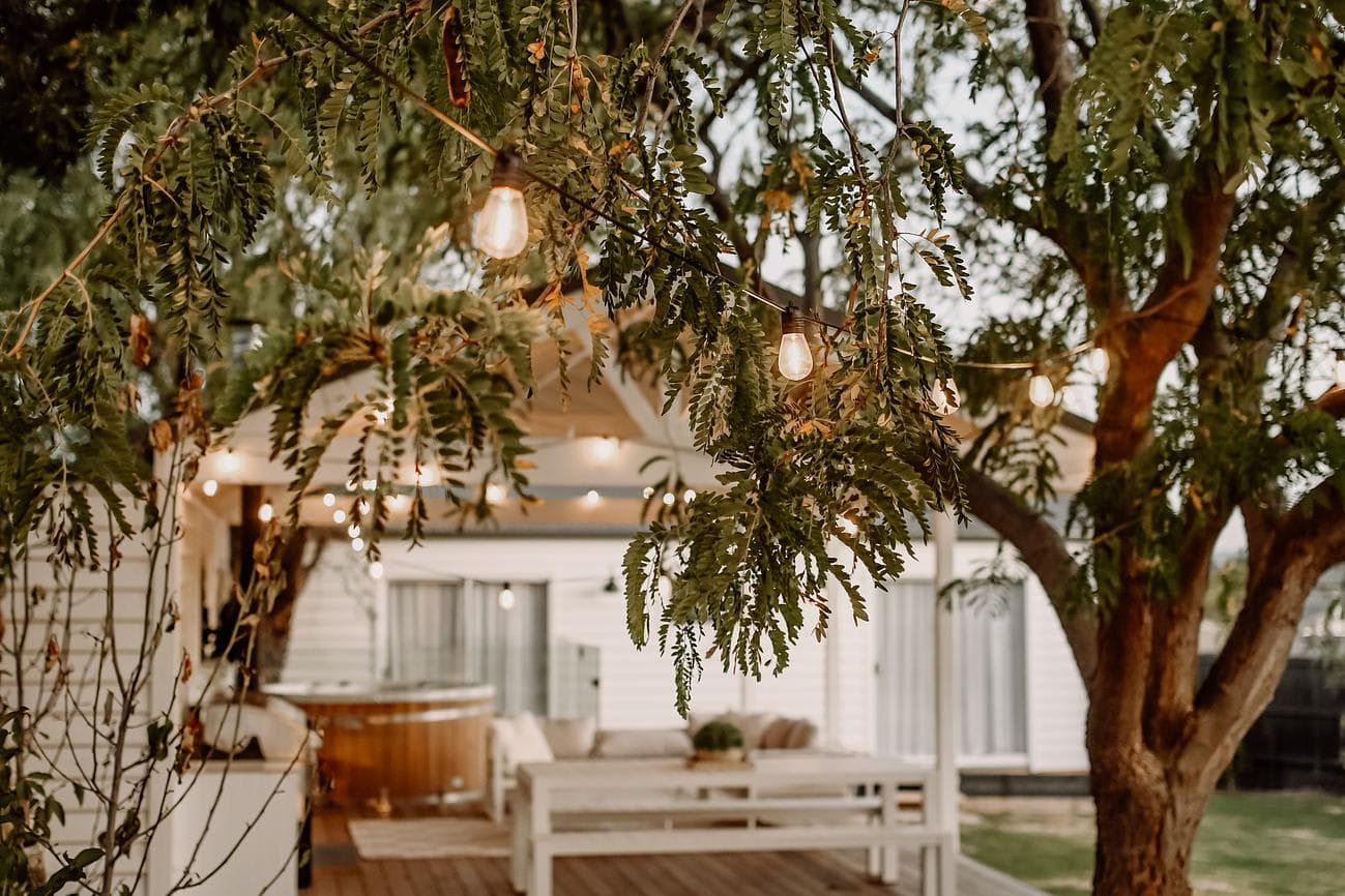 The covered deck at Bella's Cottage glowing through the trees, strung with lights
