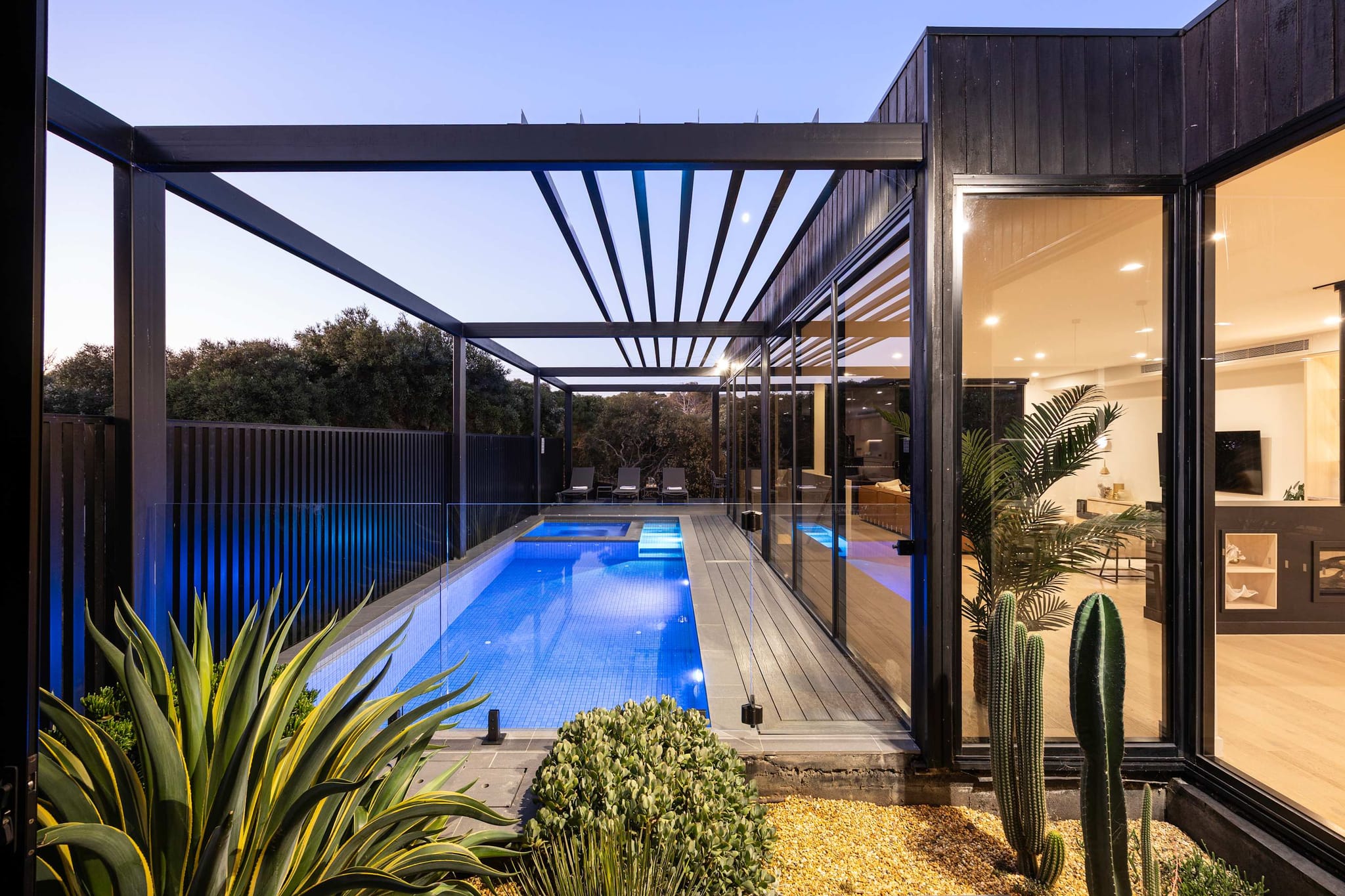 Lap pool and pergola at The Indoor-Outdoor Retreat in Rye at dusk