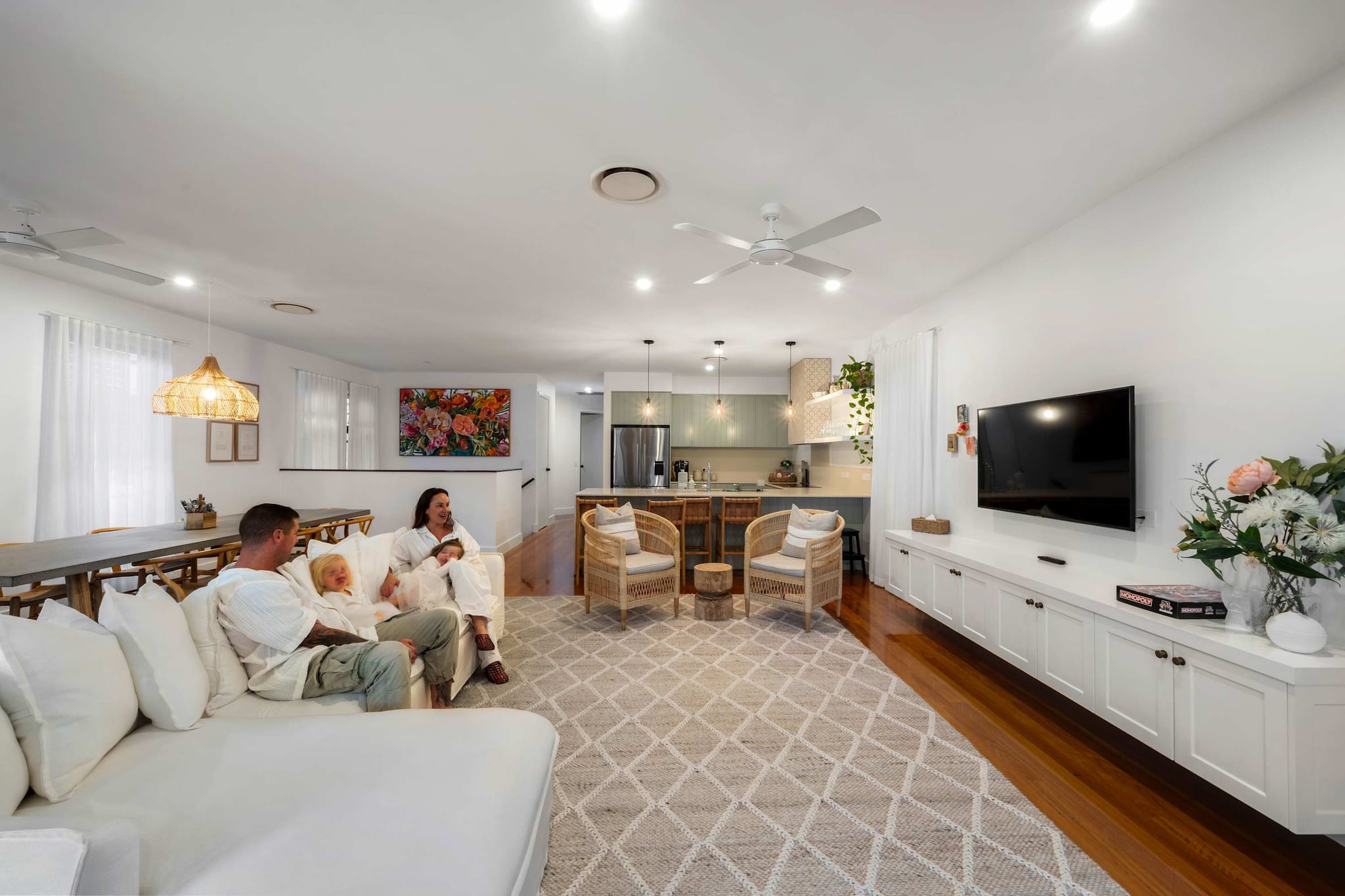 The living room at The Beachside House, Burleigh Heads, with a white sofa and a large TV