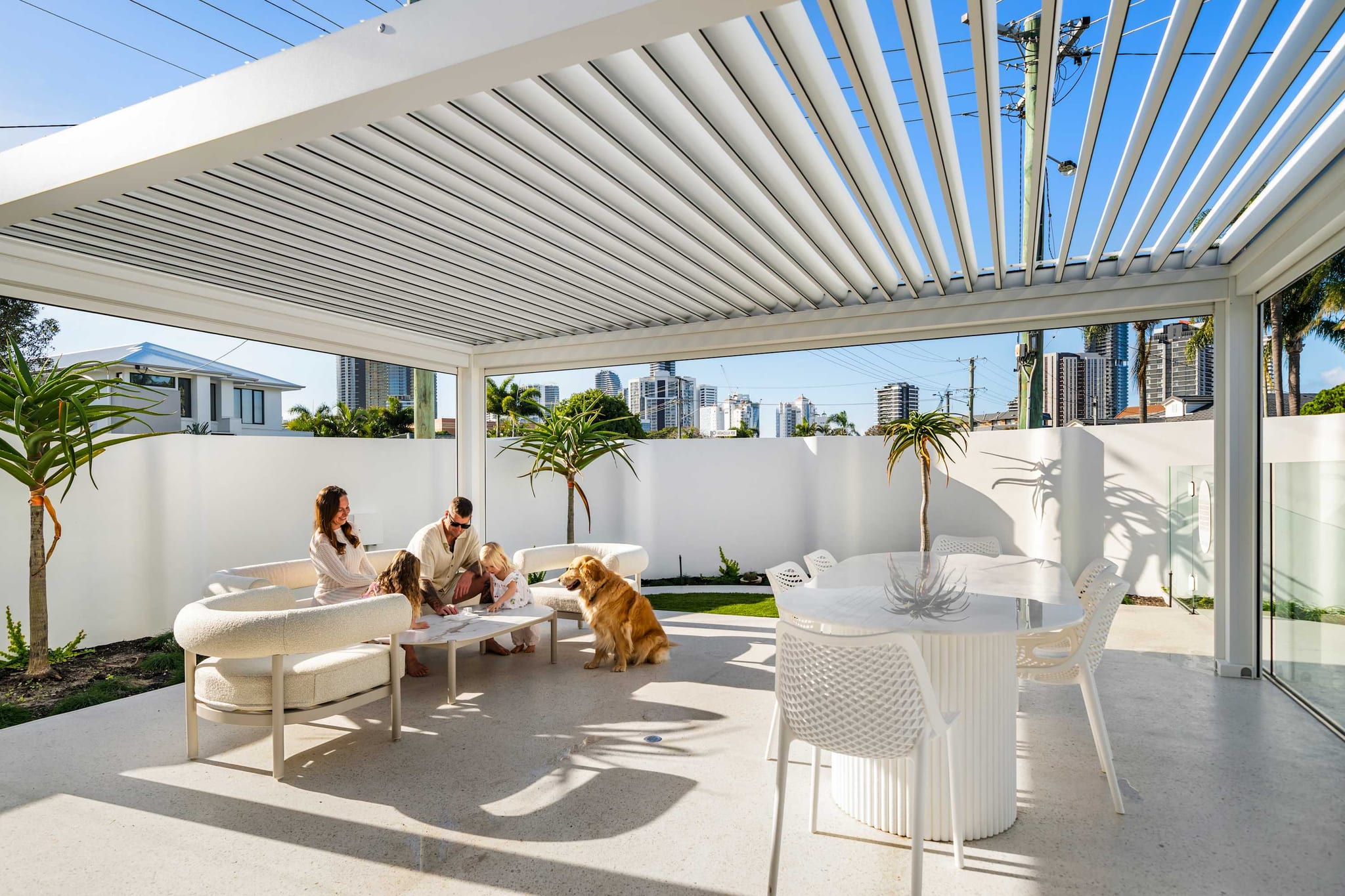 A family and their dog under the louvred roof of the outdoor pavilion at The Pavilion, Mermaid Waters