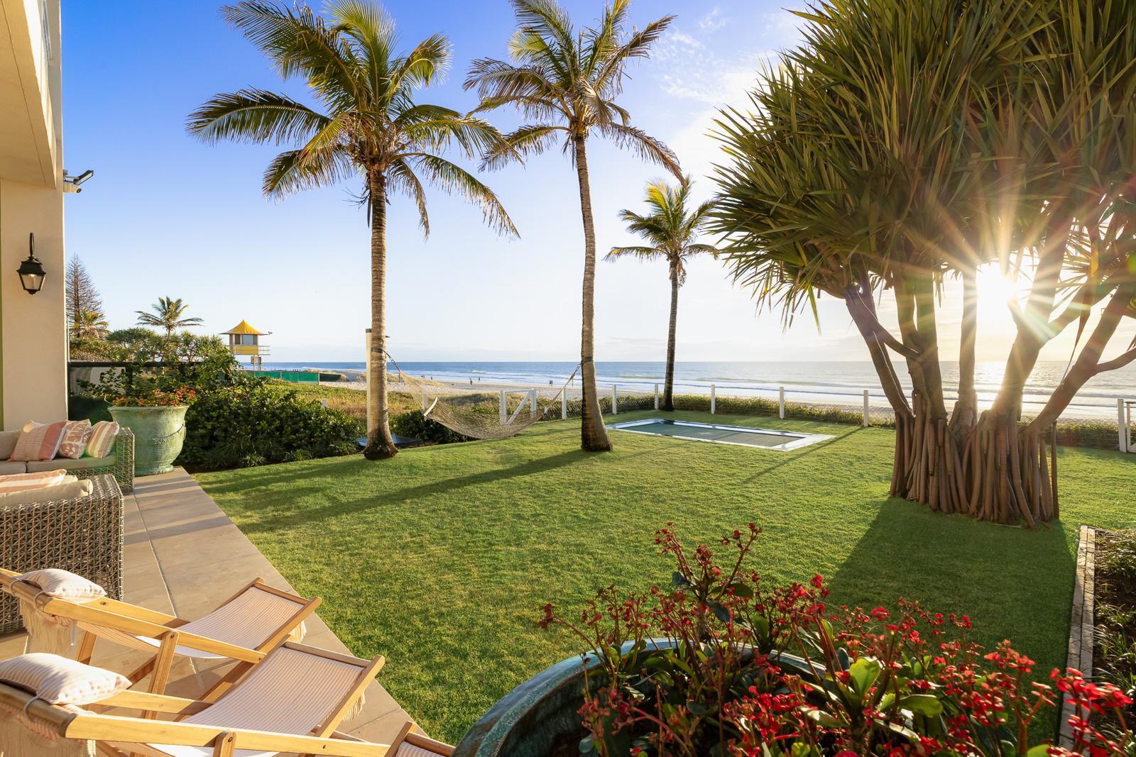 Lawn and palms running down to the beach gate