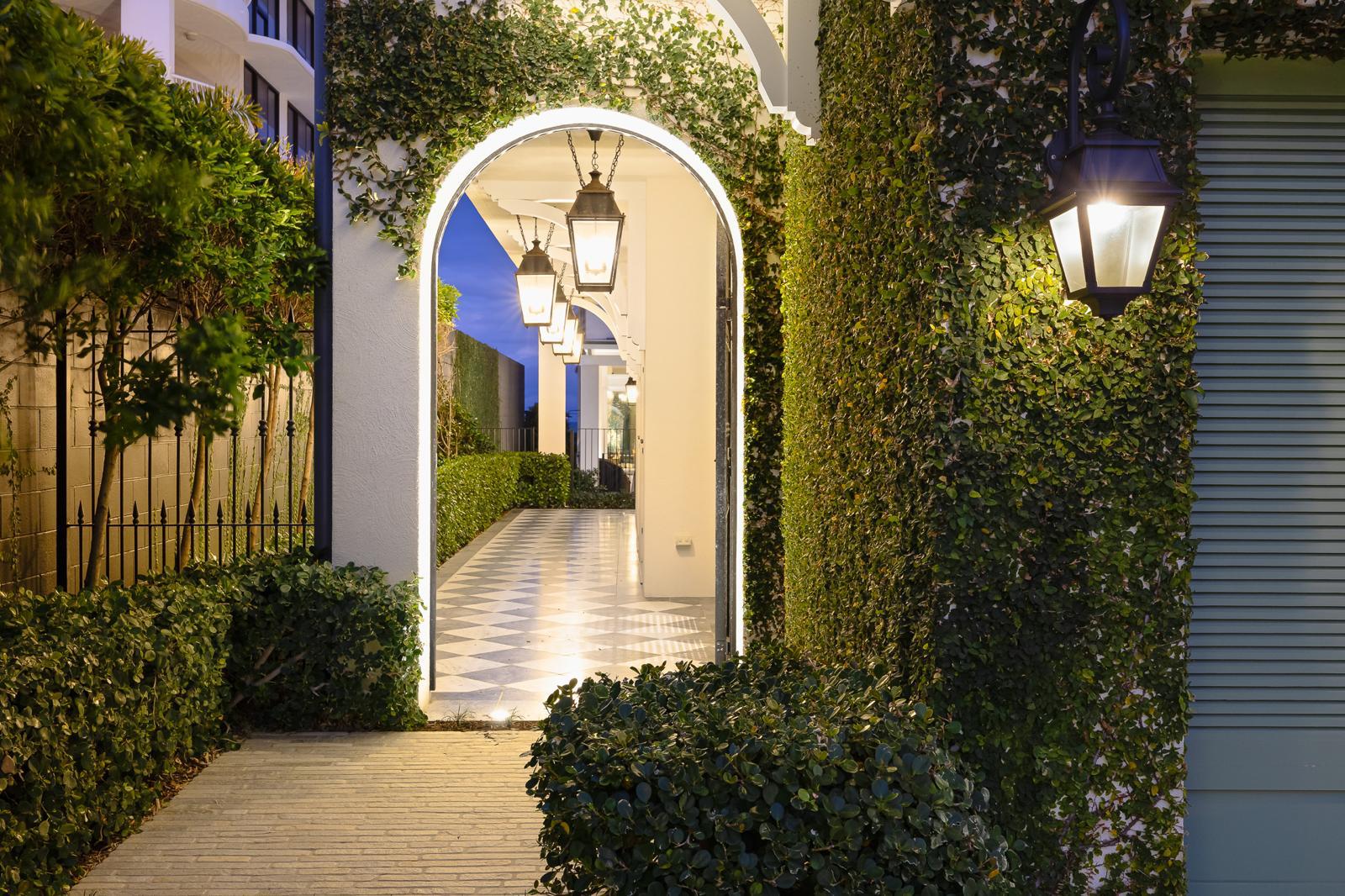 Arched entry walkway framed in greenery